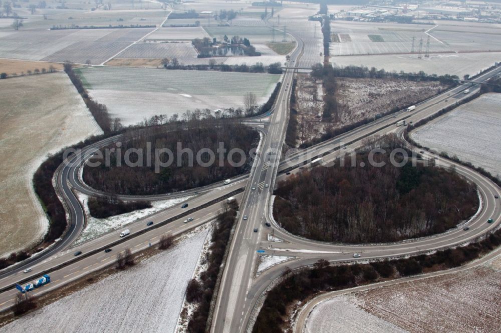 Hockenheim from above - Wintry snowy Routing and traffic lanes during the highway exit and access the motorway A 61 in Hockenheim in the state Baden-Wuerttemberg