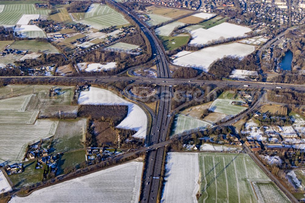 Bettenkamp from above - Wintry snowy autumnal discolored view of vegetation Traffic routing and lanes in the road layout of the Autobahn junction of the BAB A40 and BAB A57 at Kreuz Moers - laid out in the shape of a cloverleaf in Bettenkamp in the state of North Rhine-Westphalia, Germany