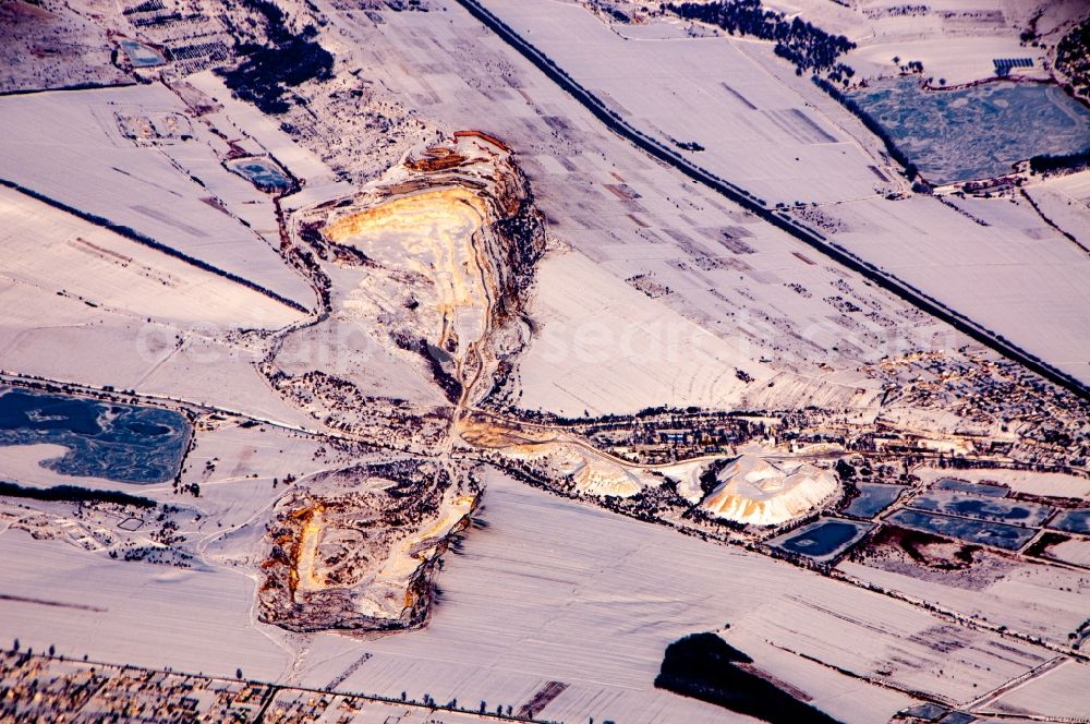 Aerial image Gornoe - Wintry snowy lake shore and overburden areas of the quarry lake and gravel open pit in Gornoe in Rajon Straseni, Moldawien