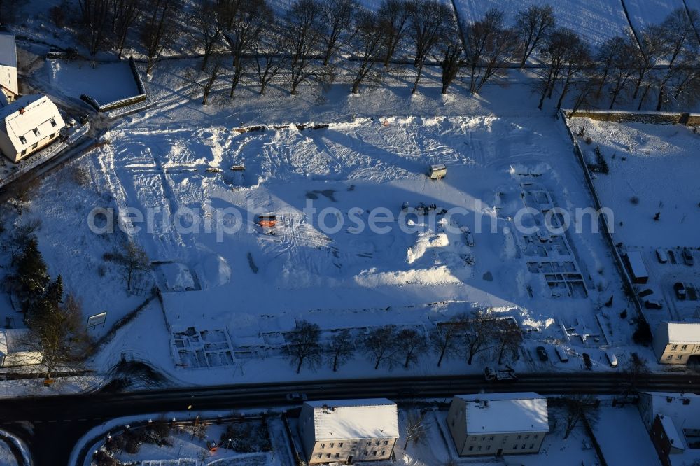 Aerial photograph Altlandsberg - Wintry snowy Construction site with development works and embankments works and archaeological digging work in Altlandsberg in the state Brandenburg