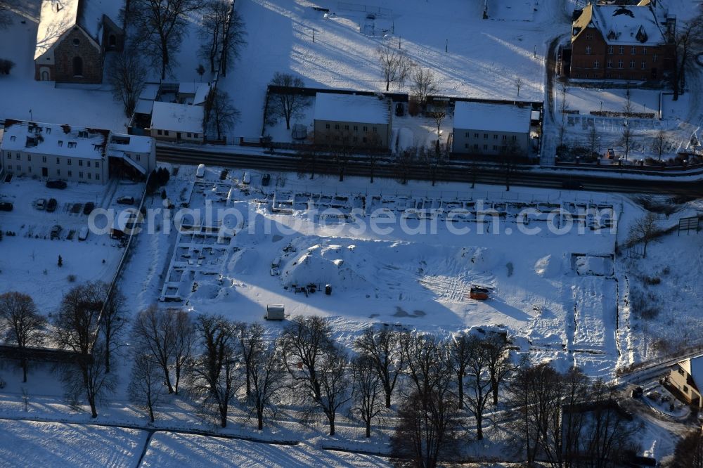 Aerial image Altlandsberg - Wintry snowy Construction site with development works and embankments works and archaeological digging work in Altlandsberg in the state Brandenburg