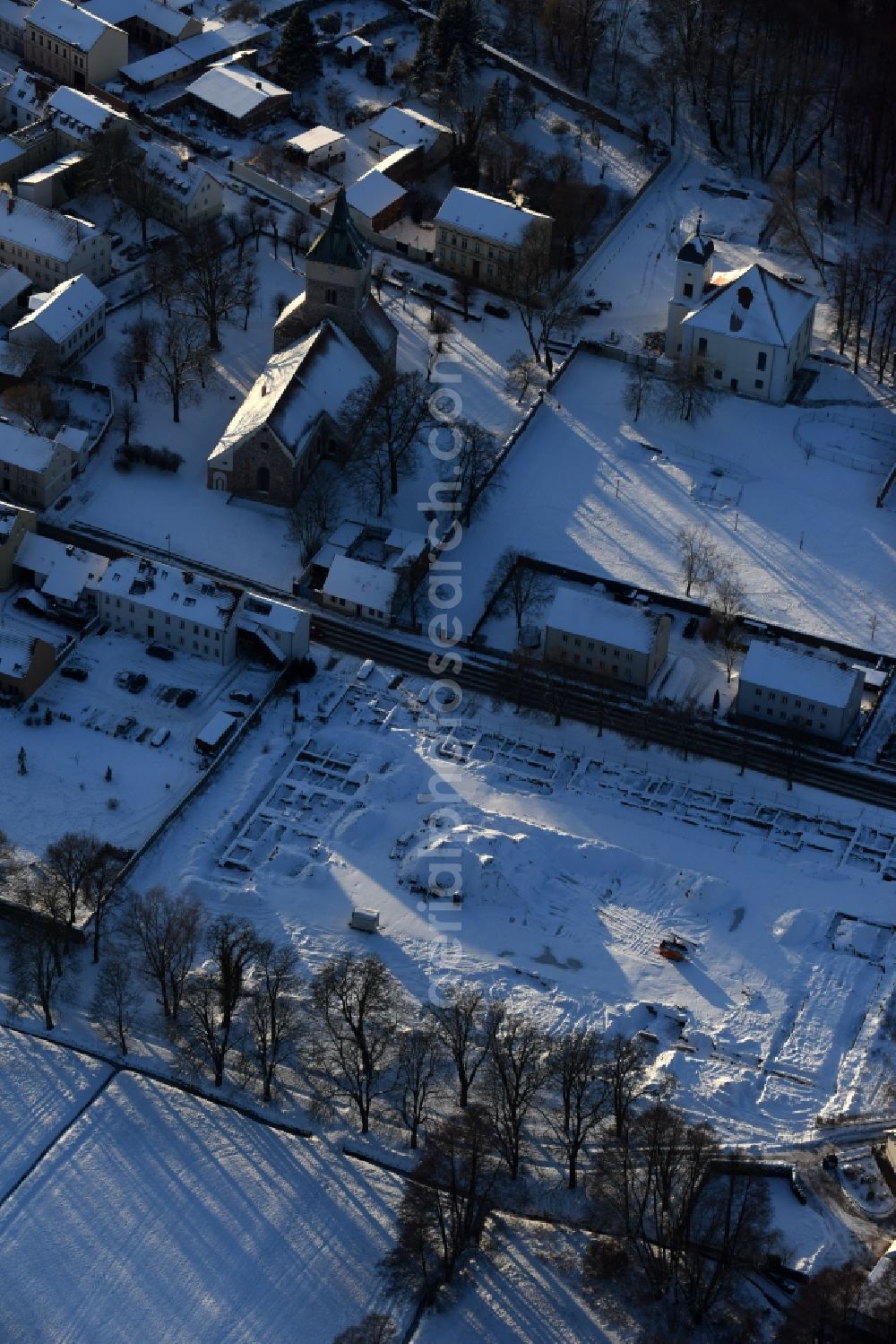 Altlandsberg from above - Wintry snowy Construction site with development works and embankments works and archaeological digging work in Altlandsberg in the state Brandenburg