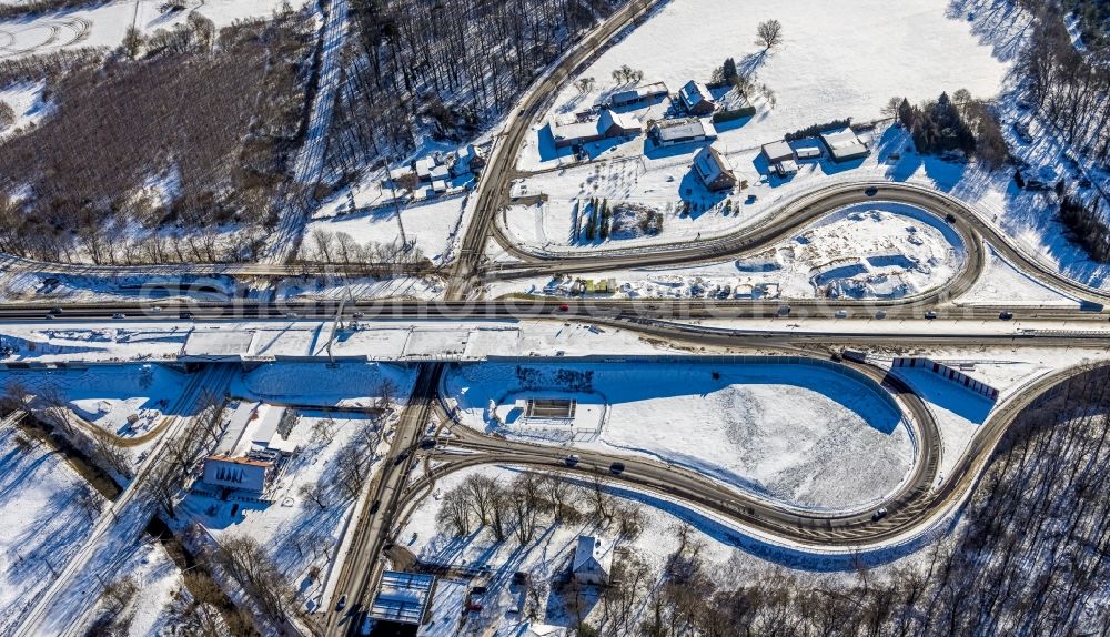 Ungelsheim from the bird's eye view: Wintry snowy construction site of ruting and traffic lanes during the exit federal highway B288 in Ungelsheim at Ruhrgebiet in the state North Rhine-Westphalia, Germany