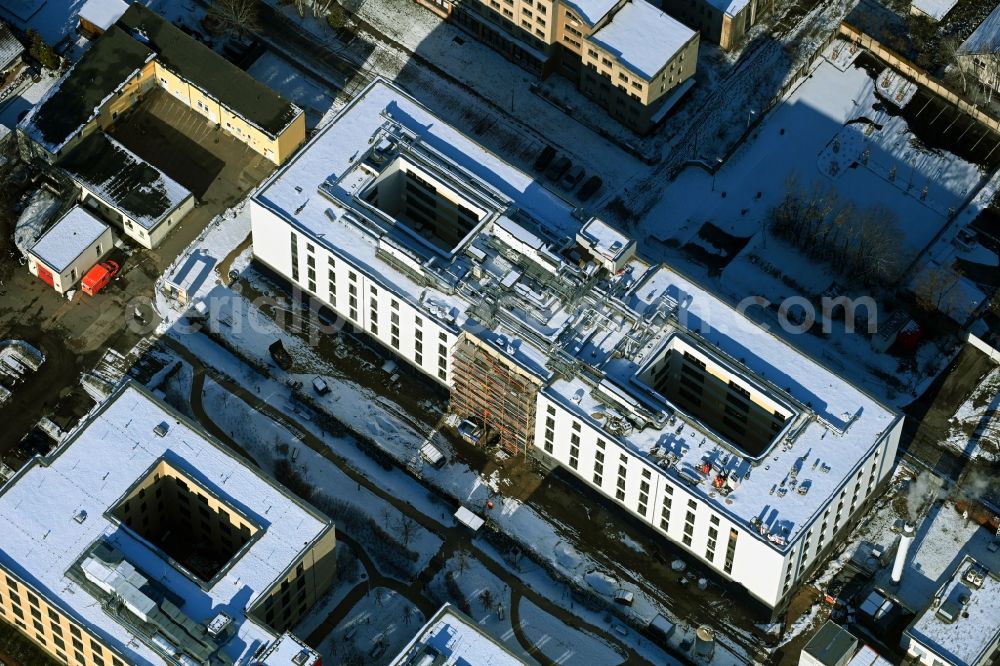 Berlin from above - Wintry snowy construction site of a new build retirement home of Vivantes Forum fuer Senioren GmbH on Muensterberger Weg in the district Kaulsdorf in Berlin, Germany