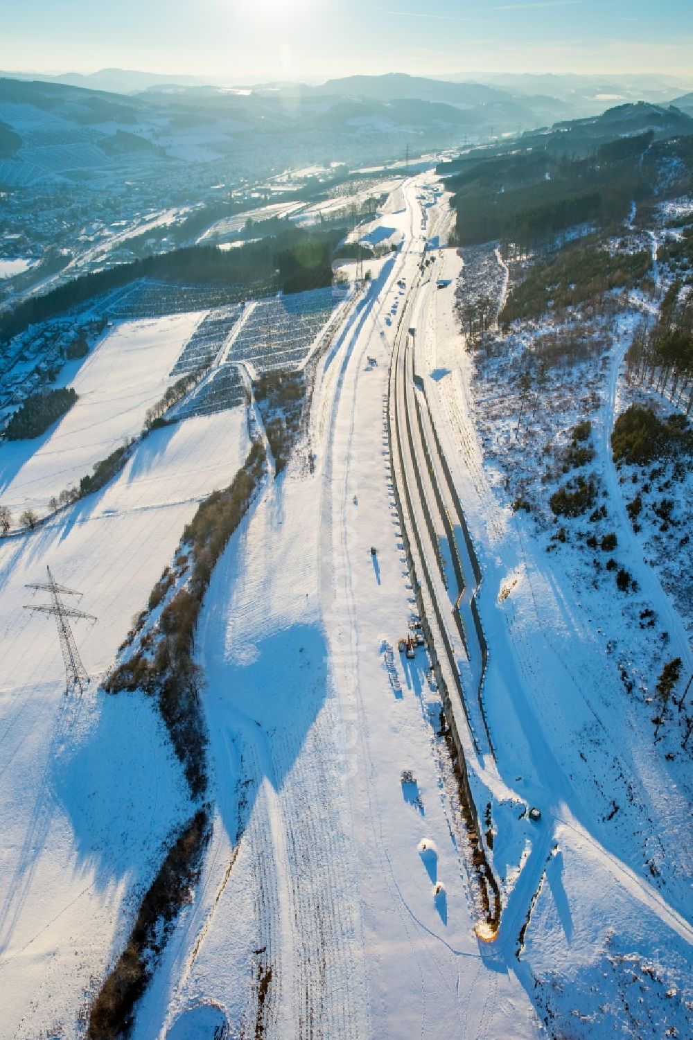 Bestwig from the bird's eye view: Wintry snowy construction site of the autobahn course of the BAB Autobahnerweiterung A46 in the district Ostwig in Bestwig in the state North Rhine-Westphalia