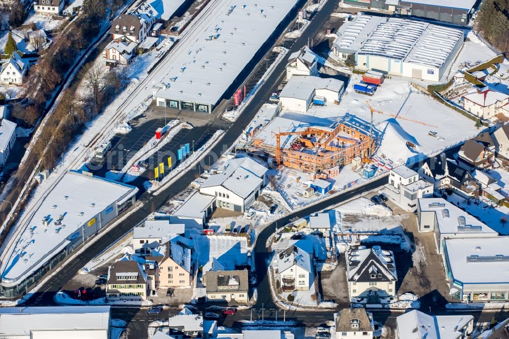 Brilon from the bird's eye view: Wintry snowy Construction site to build a new office and commercial building Freiladestrasse - Papestrasse durch die Eickmann Bauunternehmung GmbH in Brilon in the state North Rhine-Westphalia