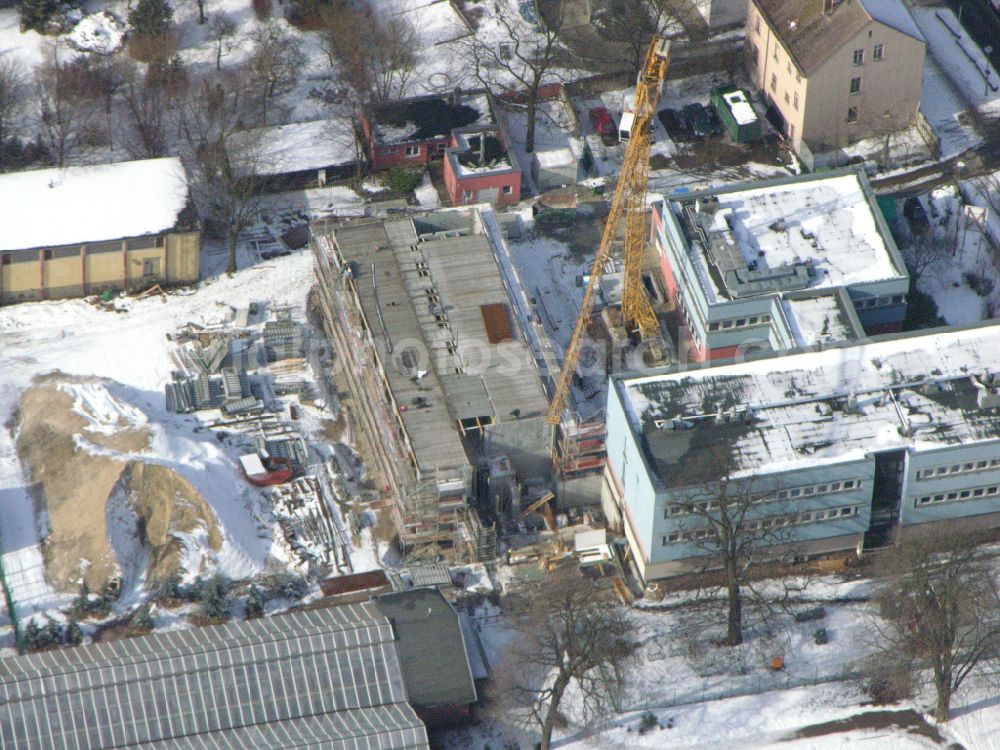 Berlin from above - Wintry snowy construction site for the new building of a research building and office complex Leibniz-Institut fuer Zoo- and Wildtierforschung (IZW) on street Alfred-Kowalke-Strasse in the district Friedrichsfelde in Berlin, Germany