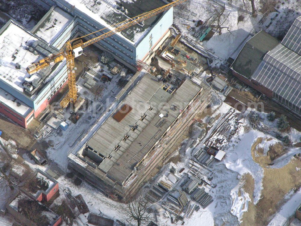 Berlin from the bird's eye view: Wintry snowy construction site for the new building of a research building and office complex Leibniz-Institut fuer Zoo- and Wildtierforschung (IZW) on street Alfred-Kowalke-Strasse in the district Friedrichsfelde in Berlin, Germany