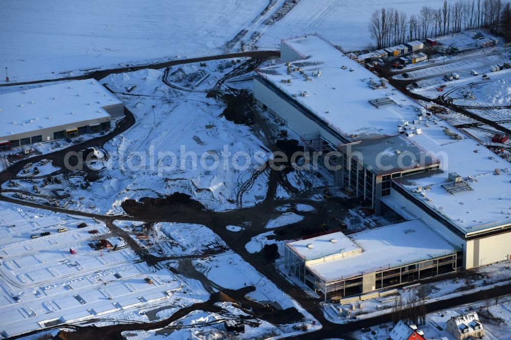 Berlin from above - Wintry snowy construction site for the new building home-center of the Porta-Group at Pilgramer street in the district Mahlsdorf in Berlin