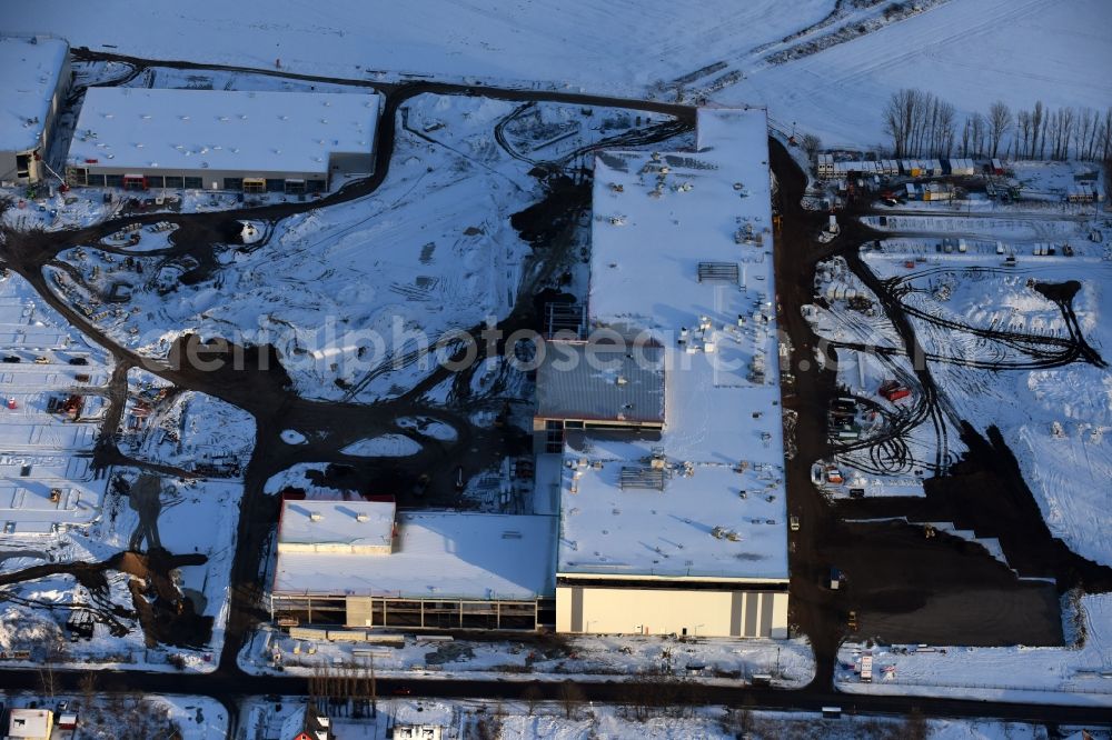 Aerial image Berlin - Wintry snowy construction site for the new building home-center of the Porta-Group at Pilgramer street in the district Mahlsdorf in Berlin