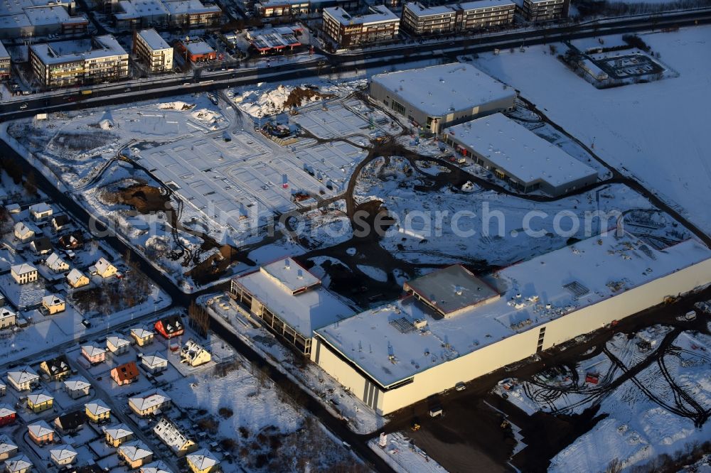 Berlin from above - Wintry snowy construction site for the new building home-center of the Porta-Group at Pilgramer street in the district Mahlsdorf in Berlin