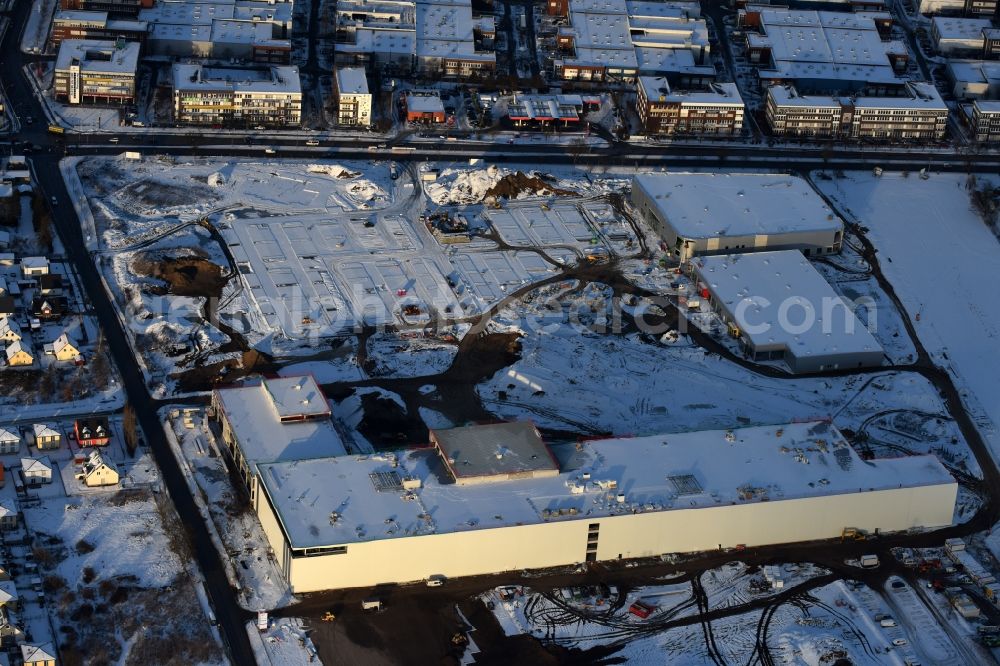 Berlin from the bird's eye view: Wintry snowy construction site for the new building home-center of the Porta-Group at Pilgramer street in the district Mahlsdorf in Berlin