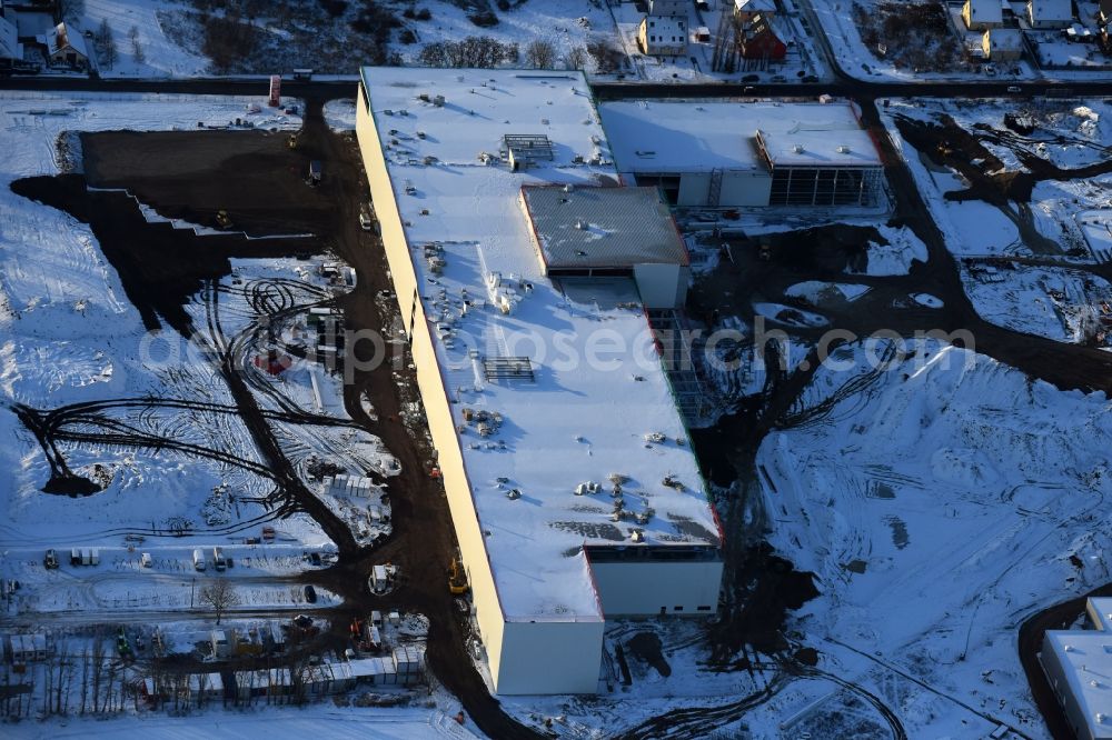 Berlin from above - Wintry snowy construction site for the new building home-center of the Porta-Group at Pilgramer street in the district Mahlsdorf in Berlin