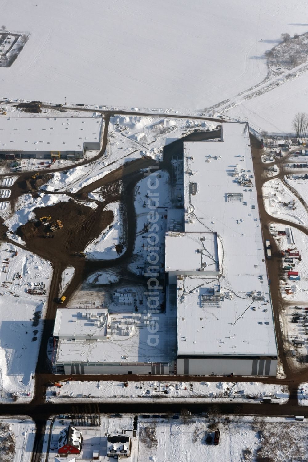 Berlin from above - Wintry snowy construction site for the new building home-center of the Porta-Group at Pilgramer street in the district Mahlsdorf in Berlin