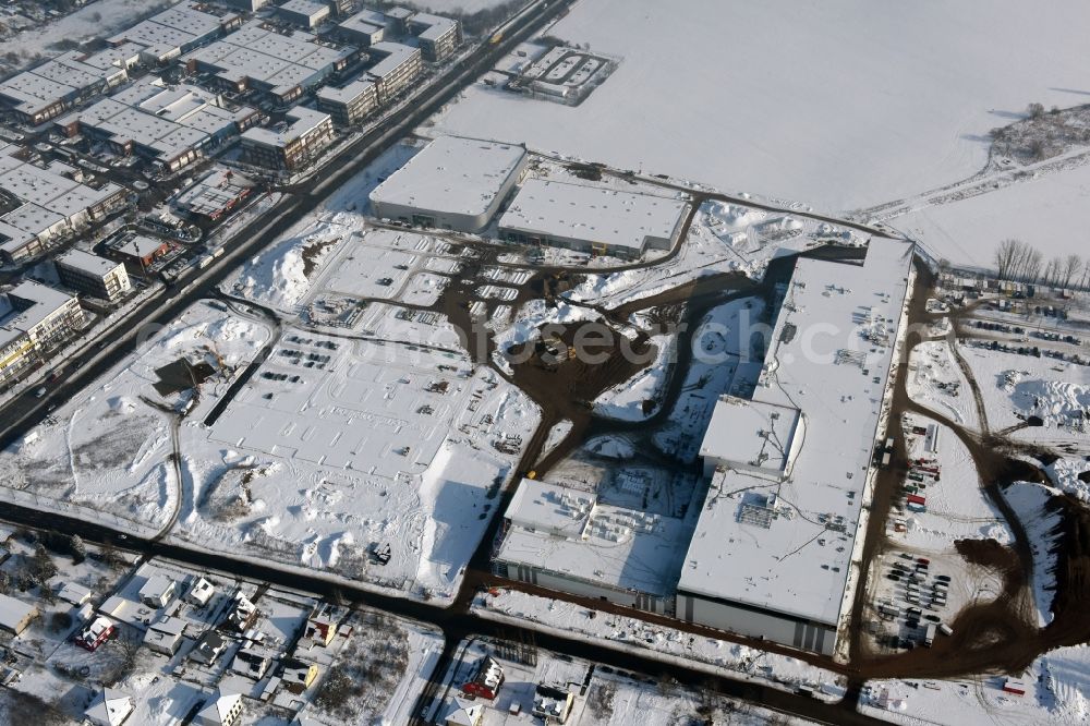 Berlin from the bird's eye view: Wintry snowy construction site for the new building home-center of the Porta-Group at Pilgramer street in the district Mahlsdorf in Berlin