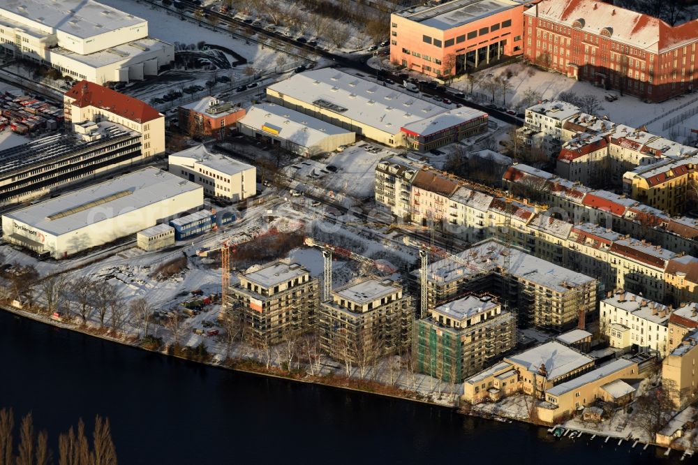 Berlin from the bird's eye view: Wintry snowy Construction site of the MBN Bau AG to build a new multi-family residential complex in the Tabbertstrasse on the river banks of the Spree in Berlin