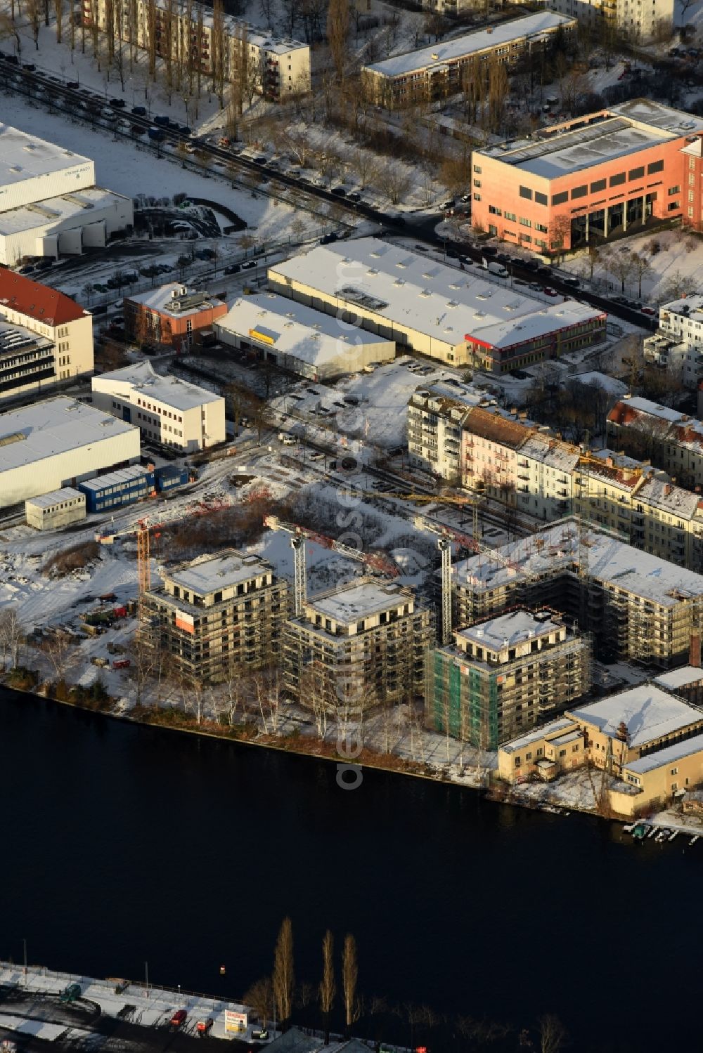 Aerial photograph Berlin - Wintry snowy Construction site of the MBN Bau AG to build a new multi-family residential complex in the Tabbertstrasse on the river banks of the Spree in Berlin