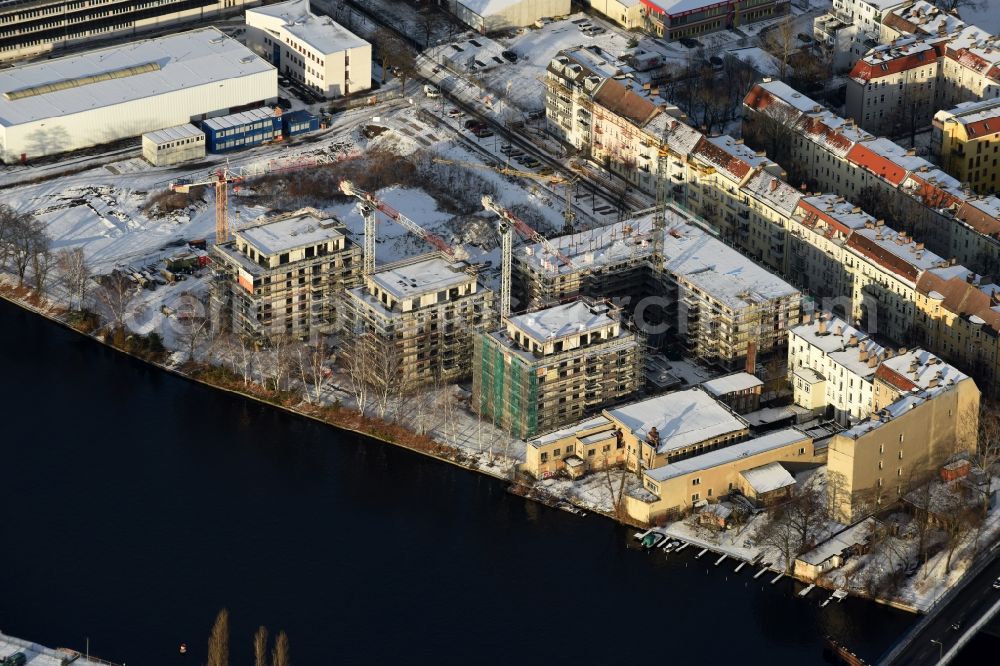 Berlin from above - Wintry snowy Construction site of the MBN Bau AG to build a new multi-family residential complex in the Tabbertstrasse on the river banks of the Spree in Berlin