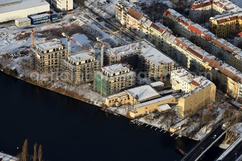 Berlin from the bird's eye view: Wintry snowy Construction site of the MBN Bau AG to build a new multi-family residential complex in the Tabbertstrasse on the river banks of the Spree in Berlin