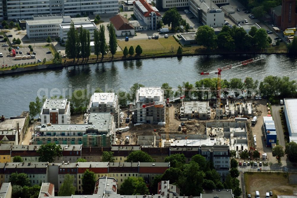 Berlin from the bird's eye view: Wintry snowy Construction site of the MBN Bau AG and E.L.I.A. Bau- & Projektmanagement GmbH to build a new multi-family residential complex in the Tabbertstrasse in Schoeneweide on the river banks of the Spree in Berlin