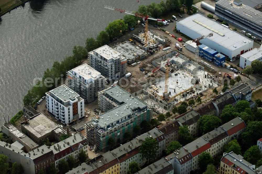 Berlin from the bird's eye view: Wintry snowy Construction site of the MBN Bau AG and E.L.I.A. Bau- & Projektmanagement GmbH to build a new multi-family residential complex in the Tabbertstrasse in Schoeneweide on the river banks of the Spree in Berlin