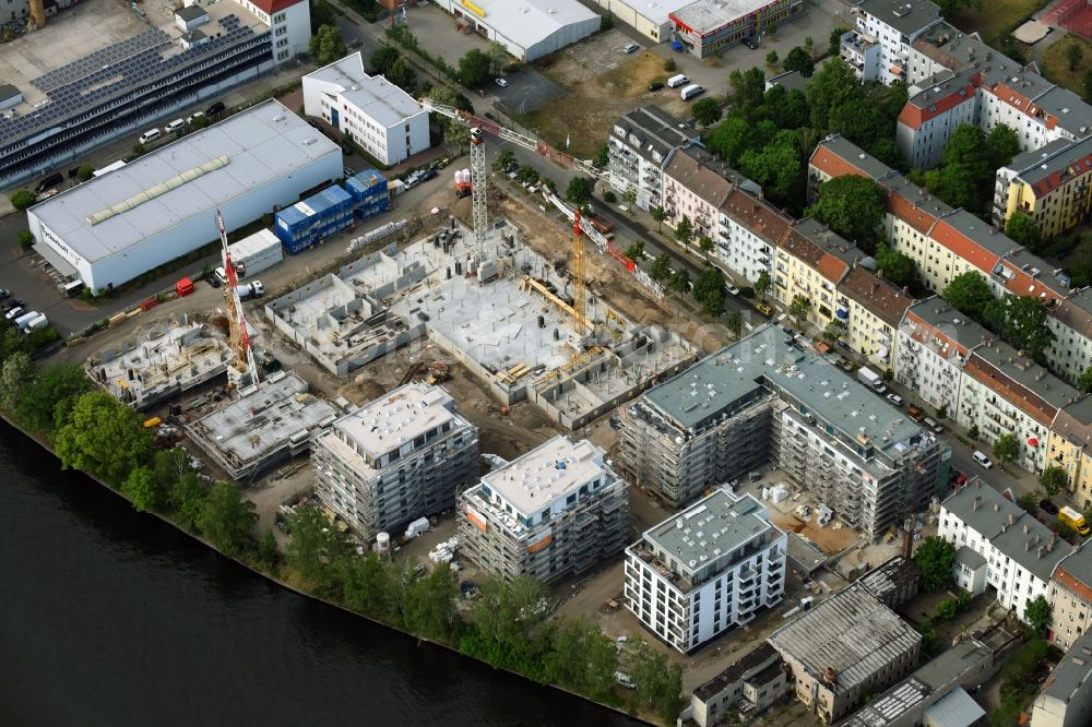 Berlin from the bird's eye view: Wintry snowy Construction site of the MBN Bau AG and E.L.I.A. Bau- & Projektmanagement GmbH to build a new multi-family residential complex in the Tabbertstrasse in Schoeneweide on the river banks of the Spree in Berlin