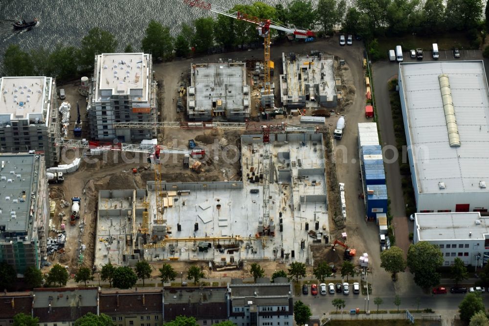 Berlin from the bird's eye view: Wintry snowy Construction site of the MBN Bau AG and E.L.I.A. Bau- & Projektmanagement GmbH to build a new multi-family residential complex in the Tabbertstrasse in Schoeneweide on the river banks of the Spree in Berlin