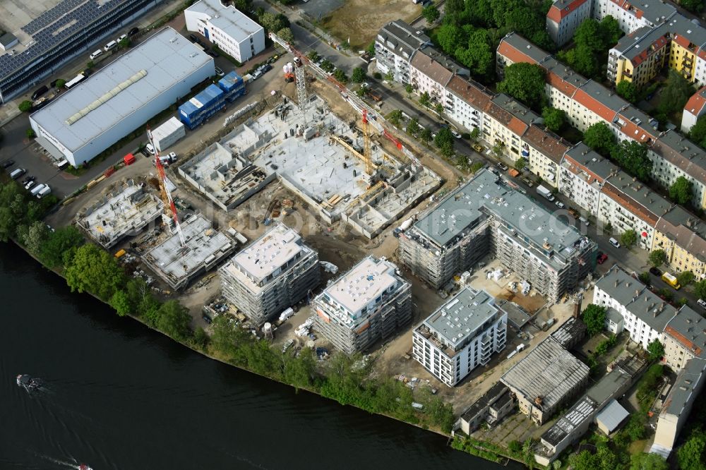 Berlin from the bird's eye view: Wintry snowy Construction site of the MBN Bau AG and E.L.I.A. Bau- & Projektmanagement GmbH to build a new multi-family residential complex in the Tabbertstrasse in Schoeneweide on the river banks of the Spree in Berlin