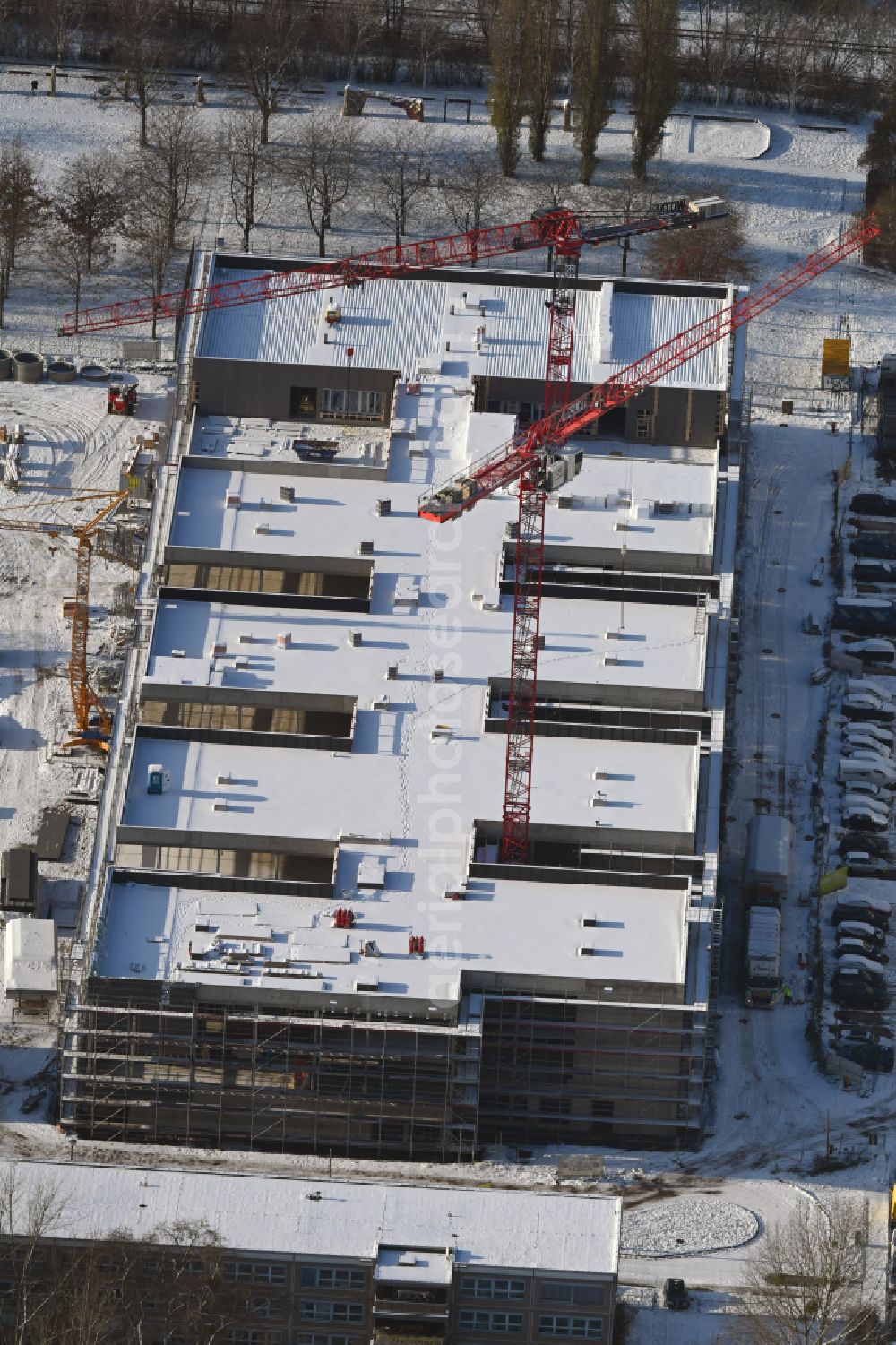 Aerial image Berlin - Wintry snowy new construction site of the school building Gymnasium with Sporthalle on street Erich-Kaestner-Strasse - Peter-Huchel-Strasse in the district Hellersdorf in Berlin, Germany