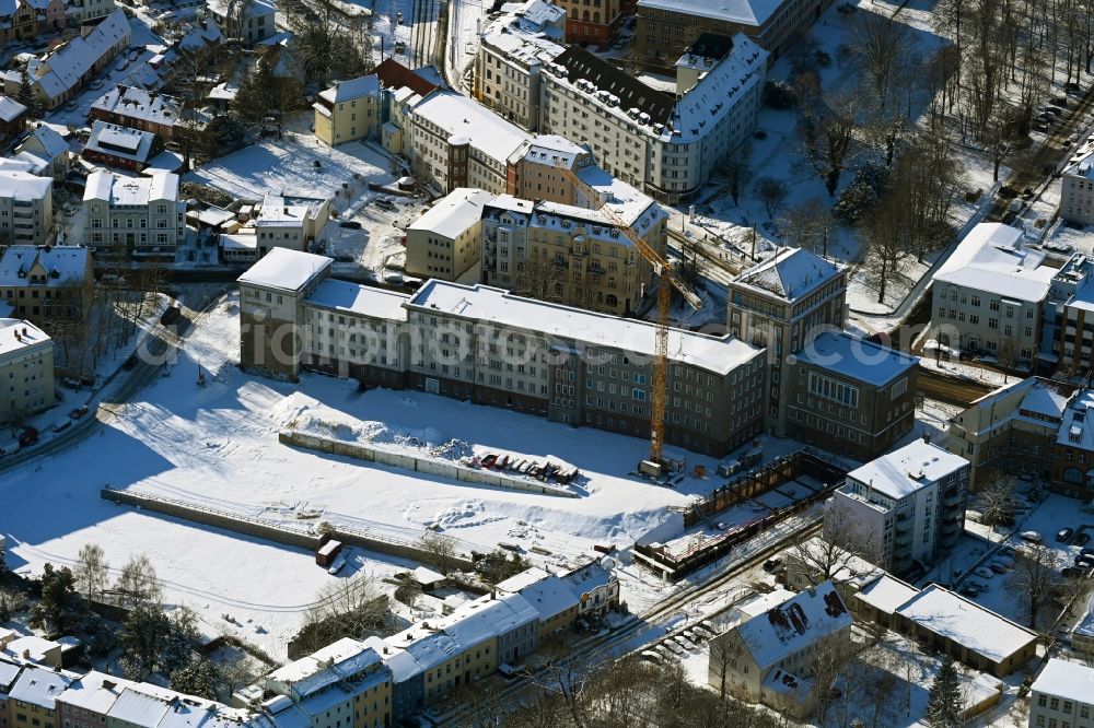 Rostock from above - Wintry snowy construction site for the multi-family residential building Am Gueterbahnhof in Rostock in the state Mecklenburg - Western Pomerania, Germany