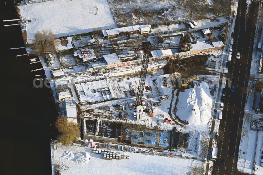 Aerial photograph Berlin - Wintry snowy construction site for the multi-family residential building on the banks of the Spree river on street Schnellerstrasse in the district Schoeneweide in Berlin, Germany