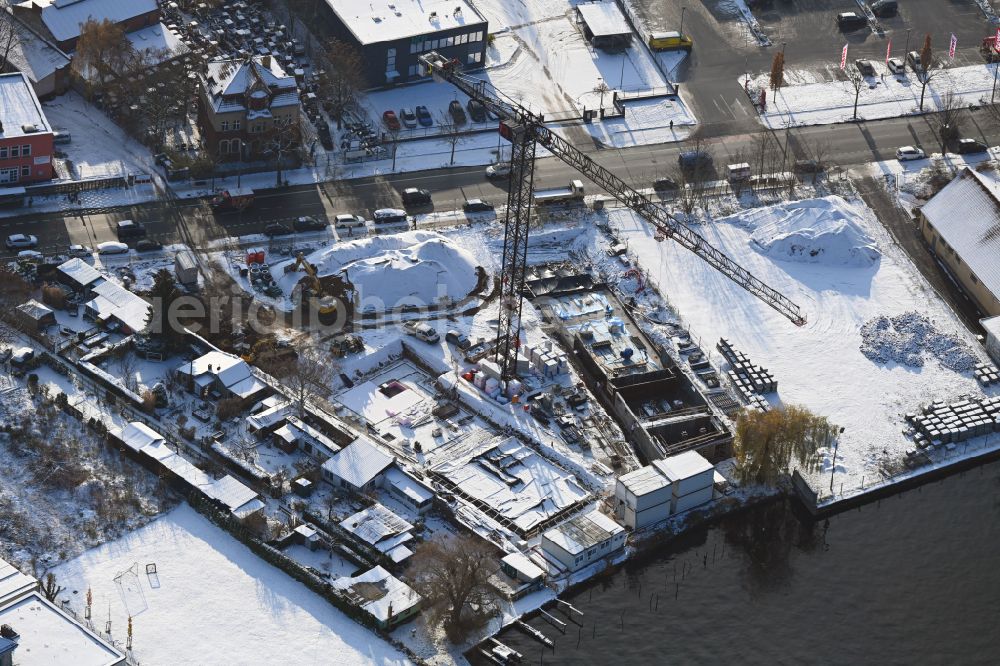 Berlin from the bird's eye view: Wintry snowy construction site for the multi-family residential building on the banks of the Spree river on street Schnellerstrasse in the district Schoeneweide in Berlin, Germany
