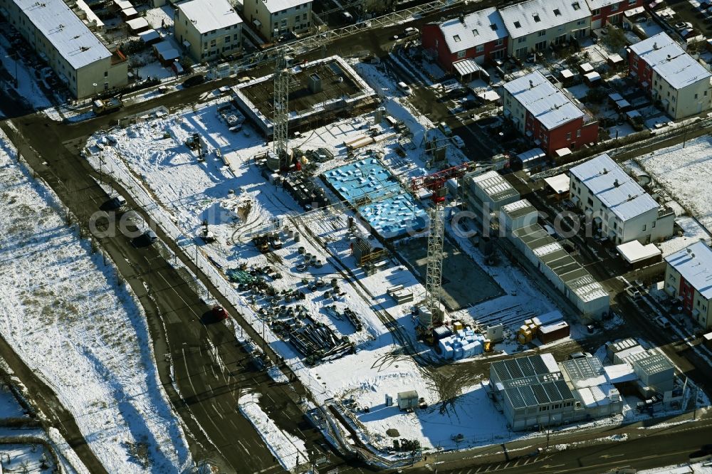 Berlin from the bird's eye view: Wintry snowy construction site for the multi-family residential building An den Rohrbruchwiesen, Daumstrasse, Glindowseestrasse in the district Haselhorst in Berlin, Germany