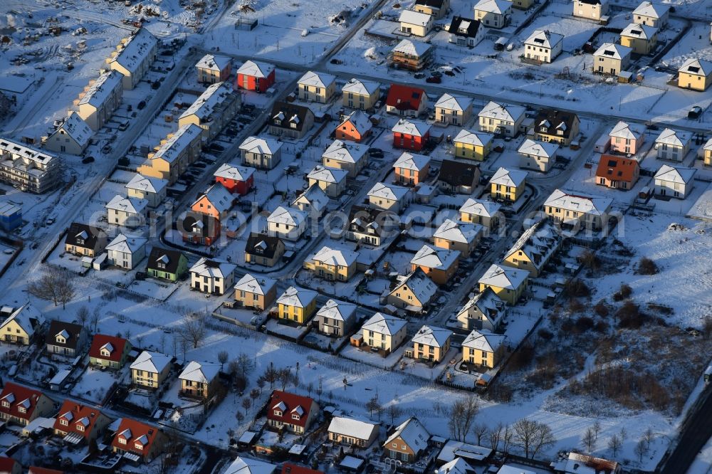 Aerial image Berlin - Wintry snowy construction sites for new construction residential area of detached housing estate at Theodorstreet at Theordorpark in the district Mahlsdorf in Berlin. Building-ower is the company Bonava