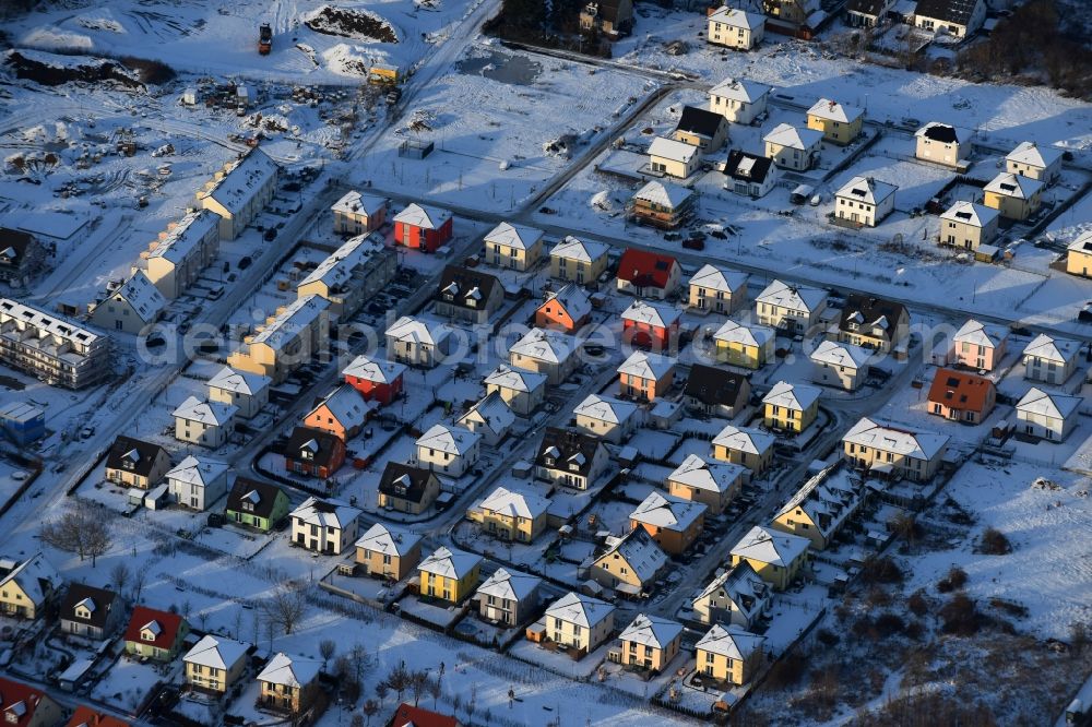 Aerial photograph Berlin - Wintry snowy construction sites for new construction residential area of detached housing estate at Theodorstreet at Theordorpark in the district Mahlsdorf in Berlin. Building-ower is the company Bonava