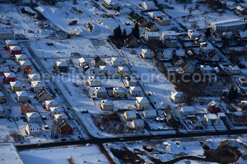 Aerial image Berlin - Wintry snowy construction sites for new construction residential area of detached housing estate at Theodorstreet at Theordorpark in the district Mahlsdorf in Berlin. Building-ower is the company Bonava