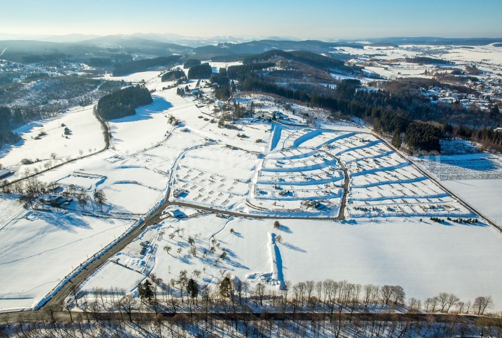 Brilon from above - Wintry snowy construction sites for new construction residential area of detached housing estate in the district Poppenberg in Brilon in the state North Rhine-Westphalia