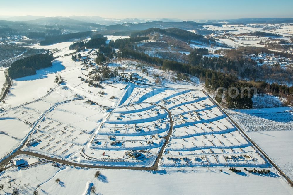 Brilon from the bird's eye view: Wintry snowy construction sites for new construction residential area of detached housing estate in the district Poppenberg in Brilon in the state North Rhine-Westphalia