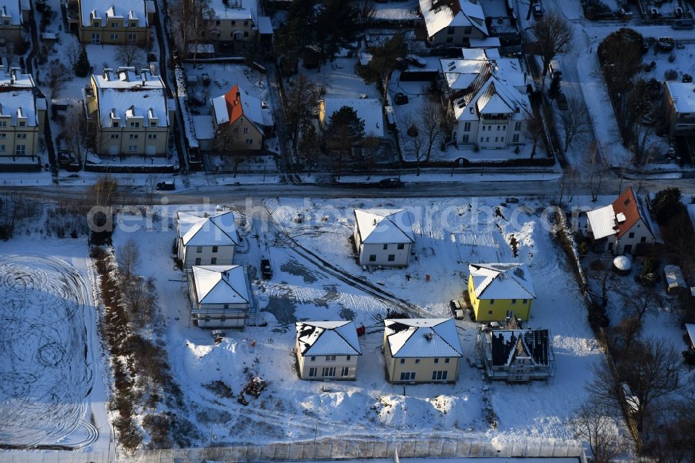 Berlin from the bird's eye view: Wintry snowy construction sites for new construction residential area of detached housing estate an der Neuenhagener Strasse in Mahlsdorf in Berlin