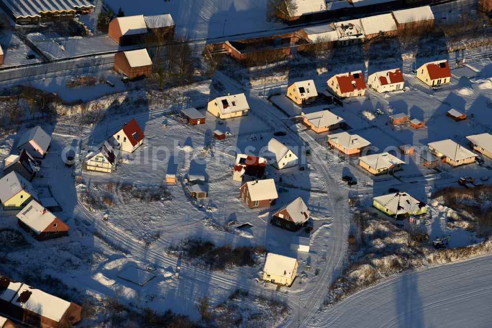 Altlandsberg from the bird's eye view: Wintry snowy Construction sites for new construction residential area of detached housing estate on Strausberger Strasse - Zur Holzseefe in Altlandsberg in the state Brandenburg