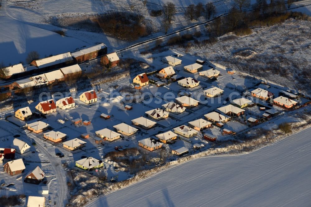 Aerial image Altlandsberg - Wintry snowy Construction sites for new construction residential area of detached housing estate on Strausberger Strasse - Zur Holzseefe in Altlandsberg in the state Brandenburg