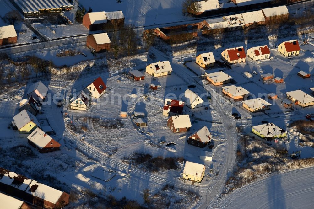 Aerial photograph Altlandsberg - Wintry snowy Construction sites for new construction residential area of detached housing estate on Strausberger Strasse - Zur Holzseefe in Altlandsberg in the state Brandenburg