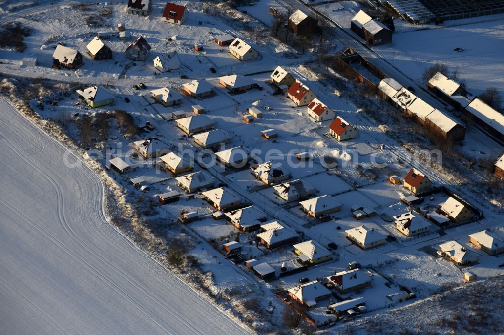 Altlandsberg from the bird's eye view: Wintry snowy Construction sites for new construction residential area of detached housing estate on Strausberger Strasse - Zur Holzseefe in Altlandsberg in the state Brandenburg