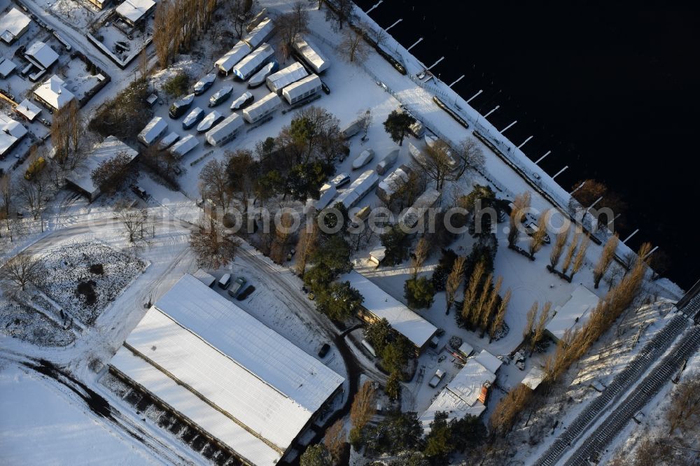 Berlin from the bird's eye view: Wintry snowy boat House ranks with the recreational marine jetties and boat mooring area on the banks of spree river on Motorwassersportclub Oberspree 1912 e.V. am Bruno-Buergel-Weg in the district Niederschoeneweide in Berlin