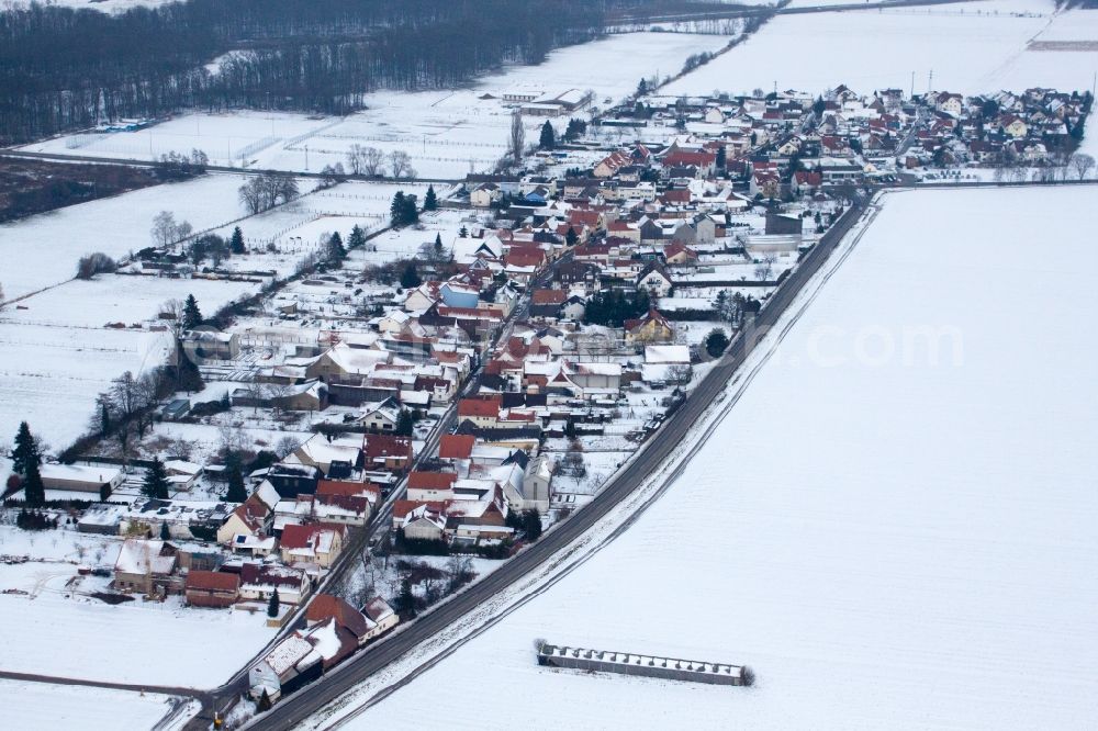 Kandel from above - Wintry snowy Village - view on the edge of agricultural fields and farmland in the district Minderslachen in Kandel in the state Rhineland-Palatinate