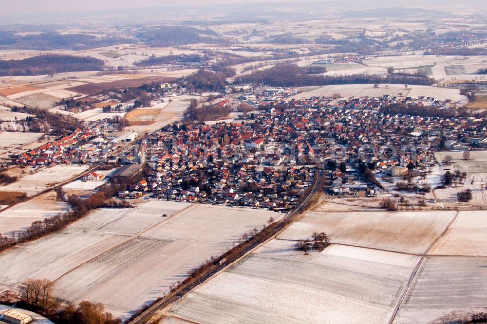 Kraichtal from the bird's eye view: Wintry snowy Village - view on the edge of agricultural fields and farmland in the district Muenzesheim in Kraichtal in the state Baden-Wuerttemberg, Germany