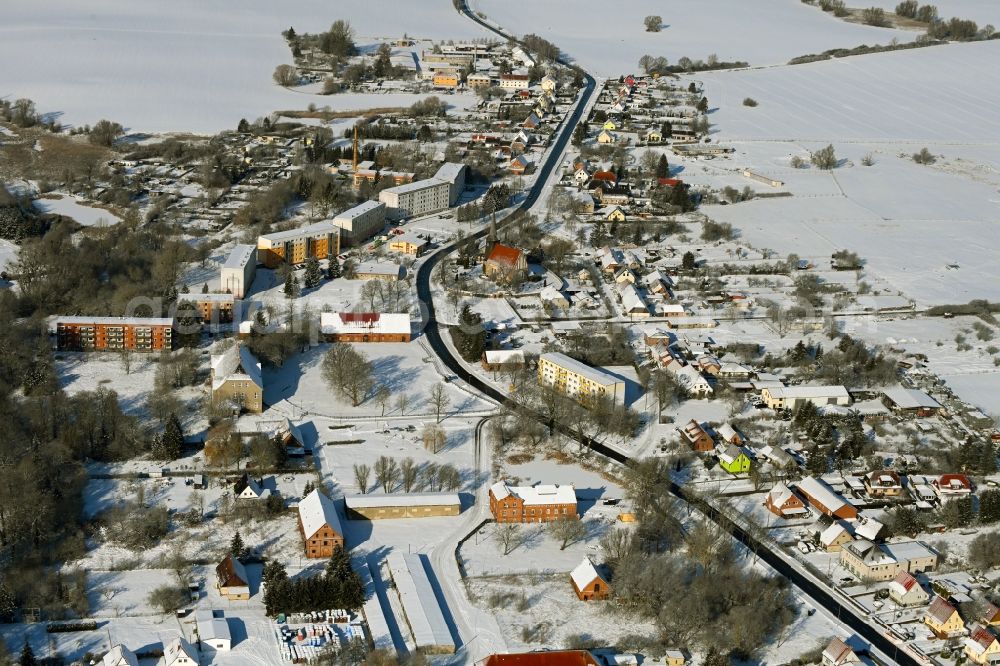 Cölpin from the bird's eye view: Wintry snowy agricultural land and field boundaries surround the settlement area of the village in Coelpin in the state Mecklenburg - Western Pomerania, Germany