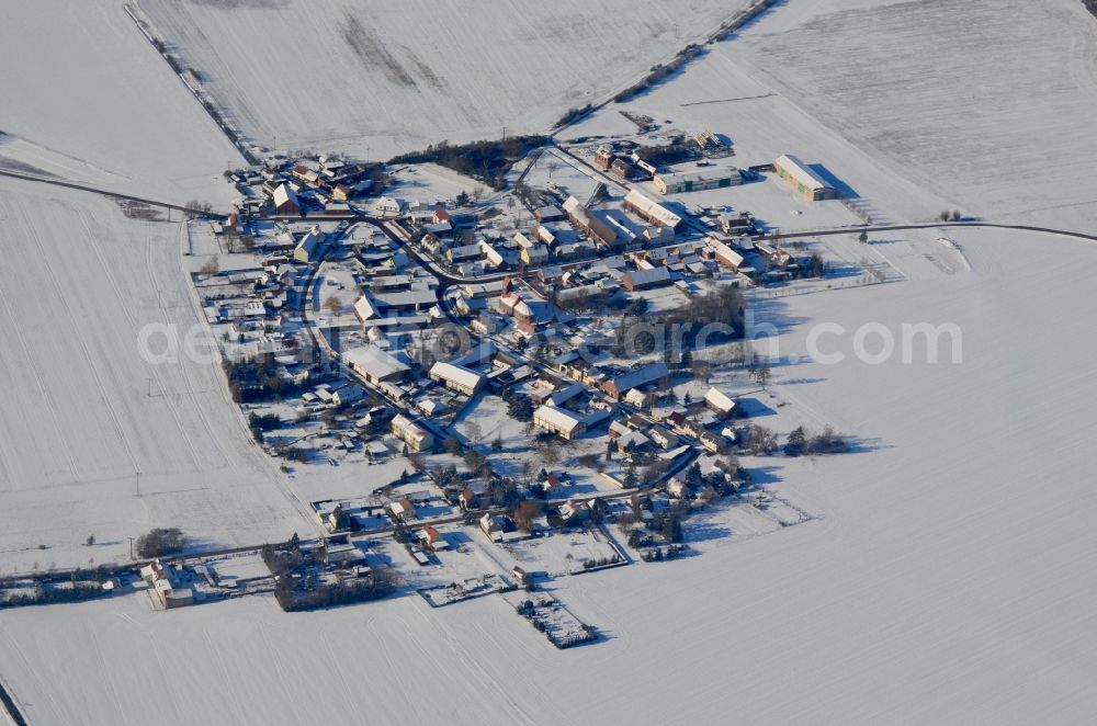 Aerial photograph Dalchau - Wintry snowy agricultural land and field boundaries surround the settlement area of the village in Dalchau in the state Saxony-Anhalt, Germany