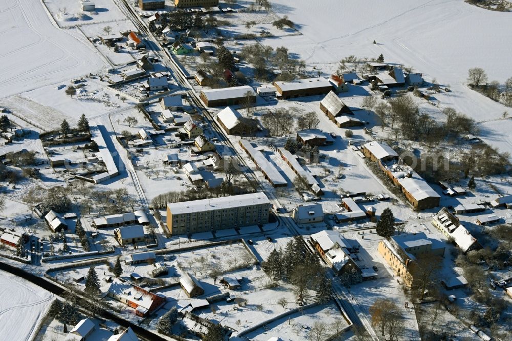 Kletzin from the bird's eye view: Wintry snowy agricultural land and field boundaries surround the settlement area of the village in Kletzin in the state Mecklenburg - Western Pomerania, Germany