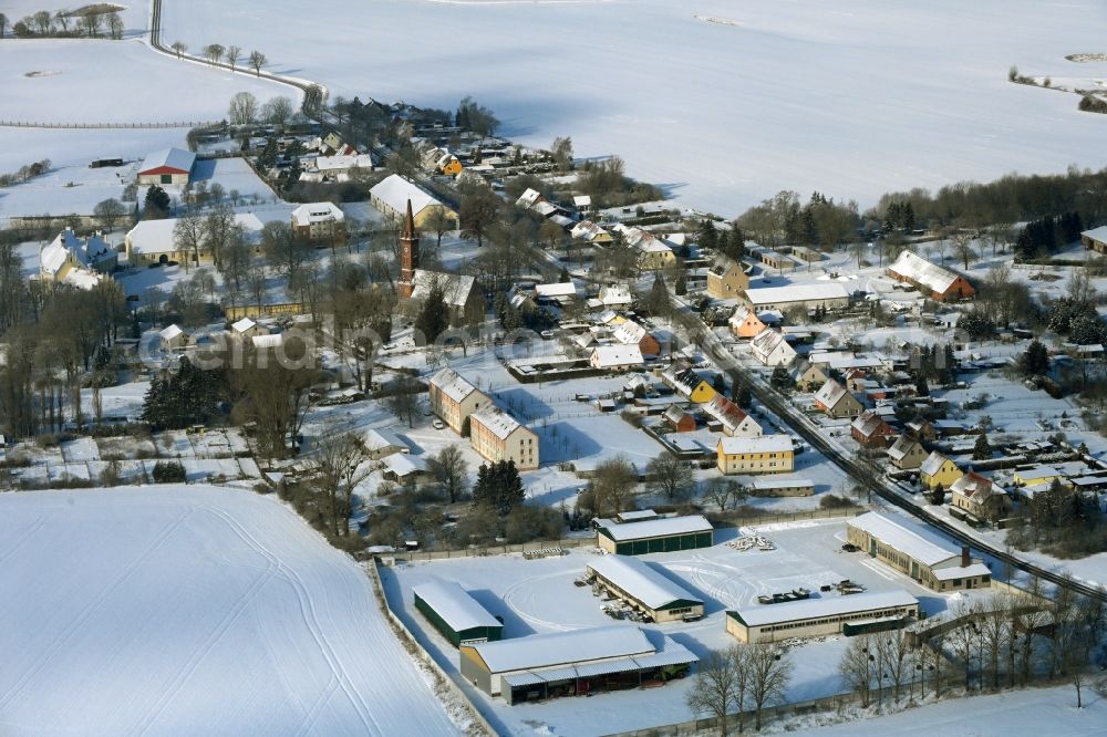 Aerial photograph Leppin - Wintry snowy agricultural land and field boundaries surround the settlement area of the village in Leppin in the state Mecklenburg - Western Pomerania, Germany